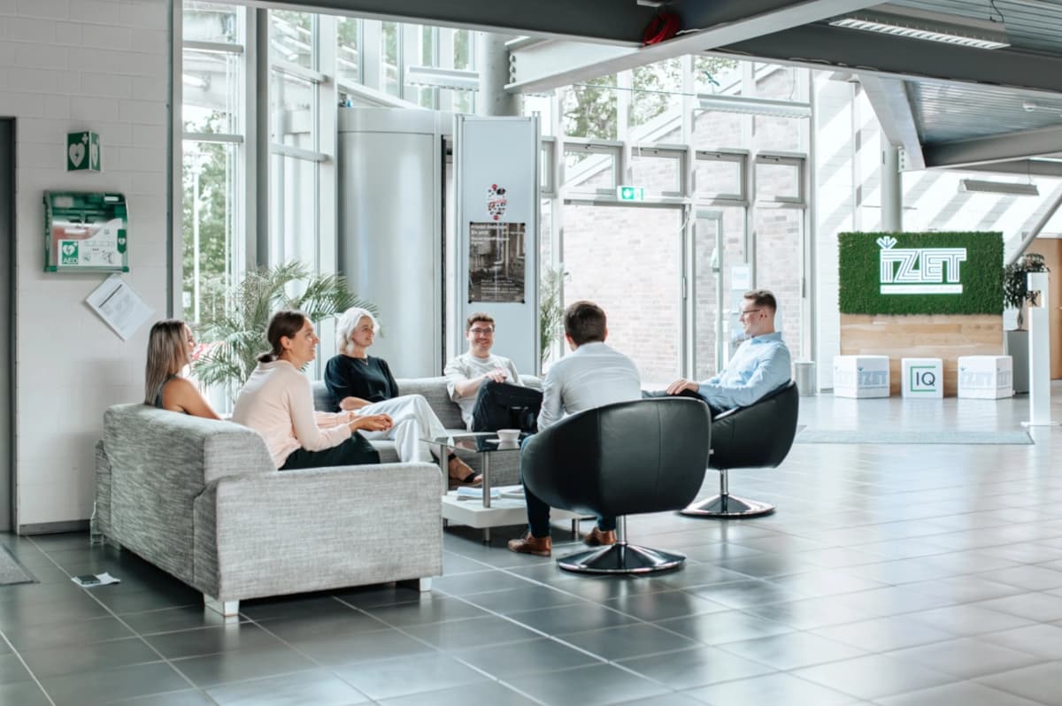 Arbeitsatmosphäre mit mehreren Personen im Foyer des IZET Innovationszentrums